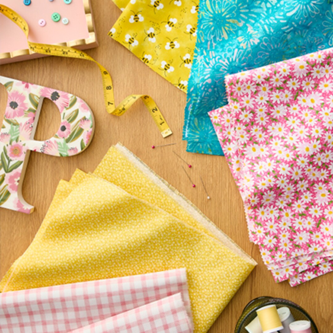 assorted pink, yellow and blue fabric cuts on wood table